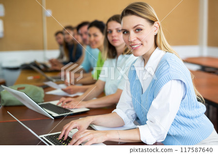 Woman studying with group of students in university 117587640