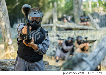 Paintball player recklessly aims with a gun on battlefield Paintball player recklessly aims with a gun on battlefield 117587793