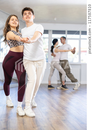 Dance studio - students in casual clothes learn to dance tango 117587810