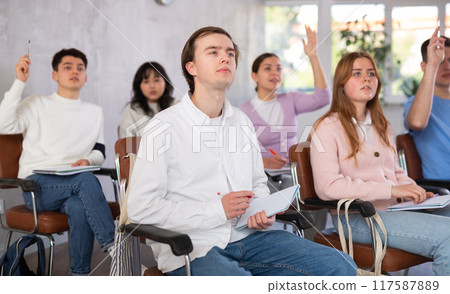 Interested guy student listening and taking notes of lecture 117587889