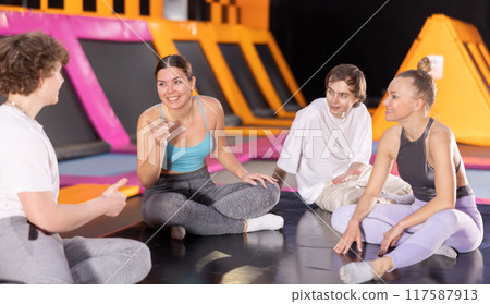 Two women and two teenager boys talking in trampoline center Two women and two teenager boys talking in trampoline center 117587913