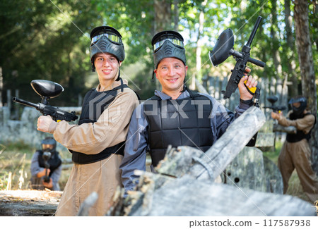Two smiling paintball players in full gear having fun before game Two smiling paintball players in full gear having fun before game 117587938