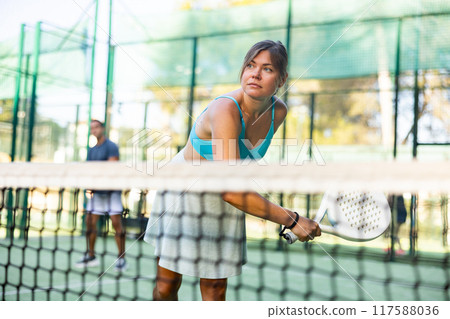 Active womans with enthusiasm playing padel on tennis court Active womans with enthusiasm playing padel on tennis court 117588036