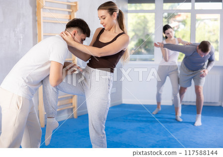 Young woman and guy training self-defense techniques Young woman and guy training self-defense techniques 117588144