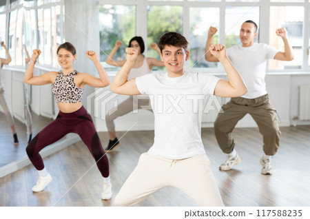 Young guy and international dancers preparing their modern dance performance at dance studio 117588235