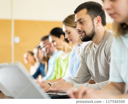 Adult students listening task for exam in classroom 117588300