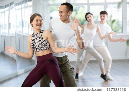 Joyful girl and guy performing lively Charleston together Joyful girl and guy performing lively Charleston together 117588338