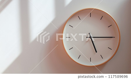 Minimalist Wooden Clock at 17.15/05.15 with Soft Shadows on White Wall - Perfect for Time Management and Lifestyle Branding 117589696