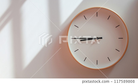 Minimalist Wooden Clock at 20.45/08.45 with Soft Shadows on White Wall - Perfect for Time Management and Lifestyle Branding 117589808