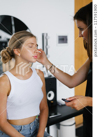 Make-up artist doing make-up girl in the salon, beauty concept Make-up artist doing make-up girl in the salon, beauty concept 117591900