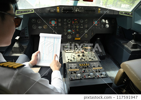Cropped shot of pilot dressed in a uniform preparing for flight in the cockpit of an aircraft Cropped shot of pilot dressed in a uniform preparing for flight in the cockpit of an aircraft 117591947