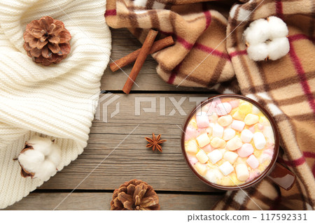 Cup of hot chocolate and marshmallows with cinnamon sticks on vintage wooden background. 117592331