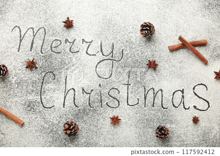 Merry Christmas text made with flour with decorations on a black stone cutting board Merry Christmas text made with flour with decorations on a black stone cutting board 117592412
