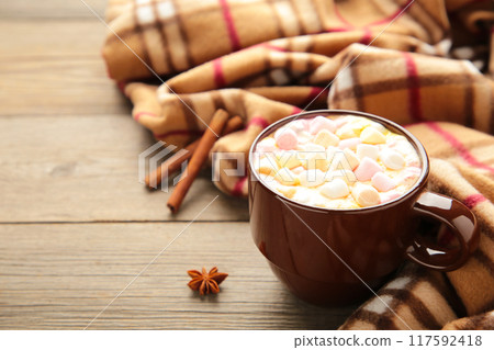 Cup of hot chocolate and marshmallows with cinnamon sticks on vintage wooden background. Cup of hot chocolate and marshmallows with cinnamon sticks on vintage wooden background. 117592418