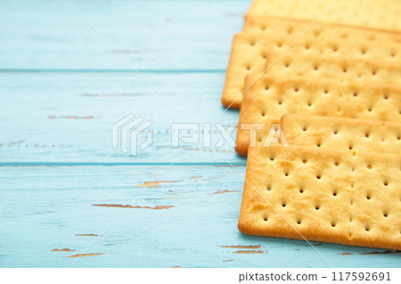 Cracker on blue wooden background with copy space. Cracker on blue wooden background with copy space. 117592691