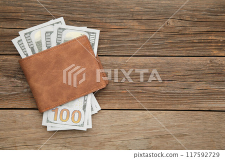 Brown leather wallet with money on grey wooden background Brown leather wallet with money on grey wooden background 117592729