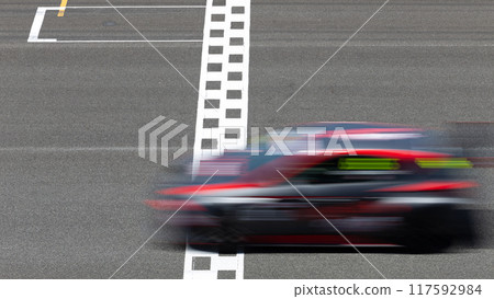 Motion blur race car racing on speed track, Car race on the international circuit race track crossing start and finish line, Race car crossing start and finish line, Target business achieve. Motion blur race car racing on speed track, Car race on the international circuit race track crossing start and finish line, Race car crossing start and finish line, Target business achieve. 117592984