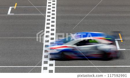 Motion blur race car racing on speed track, Car race on the international circuit race track crossing start and finish line, Race car crossing start and finish line, Target business achieve. Motion blur race car racing on speed track, Car race on the international circuit race track crossing start and finish line, Race car crossing start and finish line, Target business achieve. 117592991