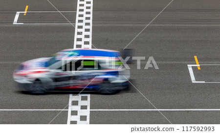 Motion blur race car racing on speed track, Car race on the international circuit race track crossing start and finish line, Race car crossing start and finish line, Target business achieve. Motion blur race car racing on speed track, Car race on the international circuit race track crossing start and finish line, Race car crossing start and finish line, Target business achieve. 117592993
