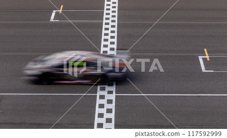 Motion blur race car racing on speed track, Car race on the international circuit race track crossing start and finish line, Race car crossing start and finish line, Target business achieve. 117592999