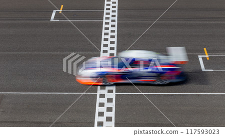 Motion blur race car racing on speed track, Car race on the international circuit race track crossing start and finish line, Race car crossing start and finish line, Target business achieve. 117593023