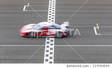 Motion blur race car racing on speed track, Car race on the international circuit race track crossing start and finish line, Race car crossing start and finish line, Target business achieve. Motion blur race car racing on speed track, Car race on the international circuit race track crossing start and finish line, Race car crossing start and finish line, Target business achieve. 117593034