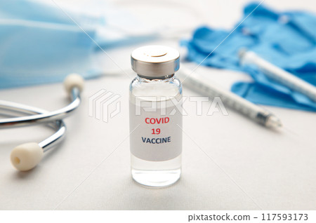 Coronavirus COVID-19 vaccine vials, syringe and stethoscope on grey background. Vaccination session and immunity improvement. Covid 19 117593173