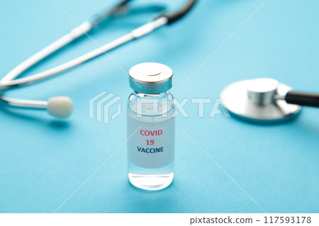 Medical bottle and stethoscope on blue background. Vaccination session and immunity improvement. Covid 19 Medical bottle and stethoscope on blue background. Vaccination session and immunity improvement. Covid 19 117593178
