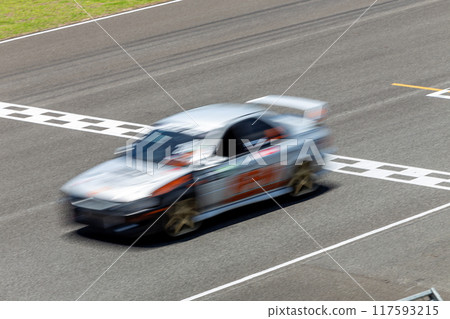 Motion blur race car racing on speed track, Car race on the international circuit race track crossing start and finish line, Race car crossing start and finish line, Target business achieve victory. 117593215