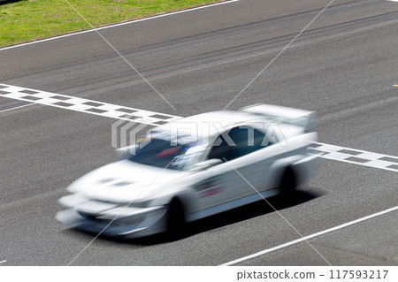 Motion blur race car racing on speed track, Car race on the international circuit race track crossing start and finish line, Race car crossing start and finish line, Target business achieve victory. 117593217