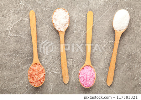 Various types of spa sea salt in wooden spoons on grey background Various types of spa sea salt in wooden spoons on grey background 117593321