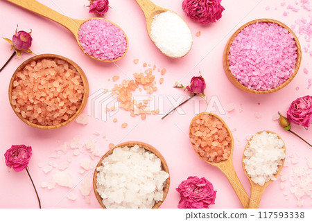 Different types of salt with roses on pink background. 117593338