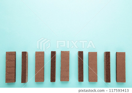 Chocolate wafers on blue background with copy space 117593413