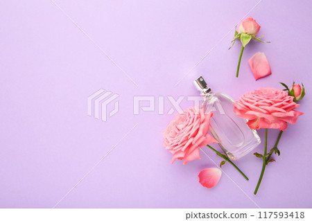 Bottle of perfume with pink roses on violet background. 117593418