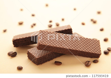 Chocolate wafers with coffee on beige background 117593419