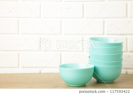 Set of stacked mint ceramic salad plates on light background. 117593422