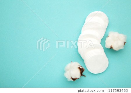 Hygienic disposable product cosmetic pads and cotton flower on blue background. Hygienic disposable product cosmetic pads and cotton flower on blue background. 117593463