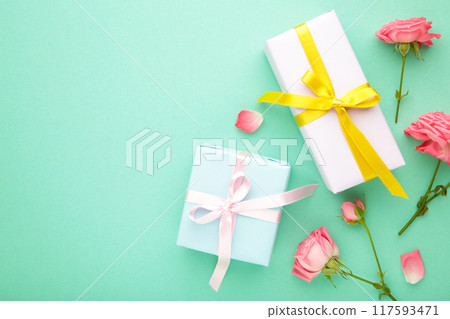 Valentines day background with pink roses and gift box on mint background. Top view. 117593471