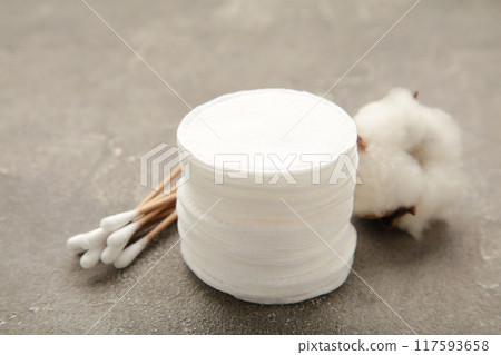 Hygienic disposable product cosmetic pads and cotton flower on grey background Hygienic disposable product cosmetic pads and cotton flower on grey background 117593658