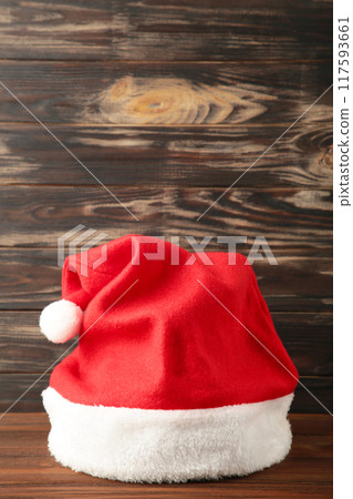 Single Santa Claus red hat on brown wooden background. 117593661