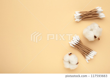 Cotton ear swabes with flower on beige background 117593663