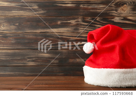 Single Santa Claus red hat on brown wooden background. 117593668