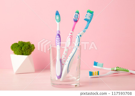 Toothbrushes in glass on pink background tools for oral care 117593708