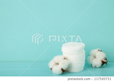 Hygienic disposable product cosmetic pads and cotton flower on blue background 117593731