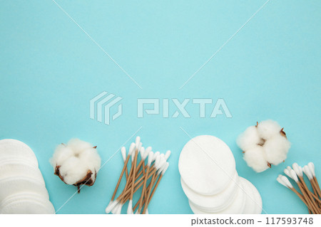 Hygienic disposable product cosmetic pads and cotton sticks on blue background 117593748