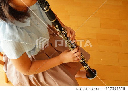 A fifth grade elementary school student who has been playing the clarinet for one year and four months practices the clarinet. 117593856