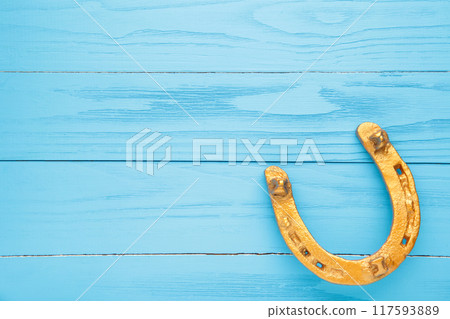 Gold horseshoe on blue background. St. Patricks day Gold horseshoe on blue background. St. Patricks day 117593889