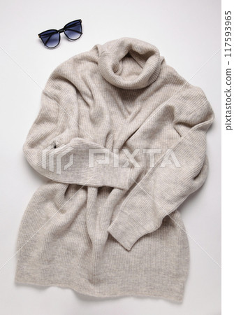 Grey knitted sweater with sunglasses on light bckground Grey knitted sweater with sunglasses on light bckground 117593965