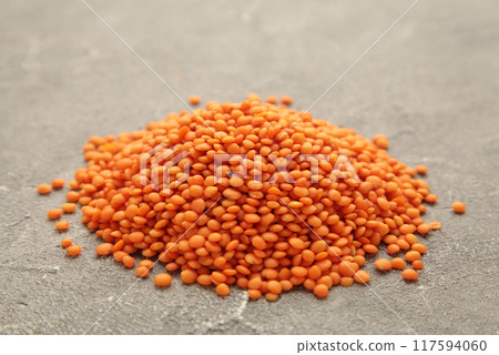 Red lentils on a grey concrete background. Red lentils on a grey concrete background. 117594060
