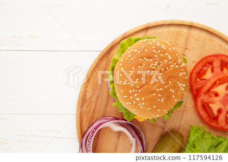 Burger steak cutlets with seasoning, cheese, tomatoes, salad and bun on white background 117594126